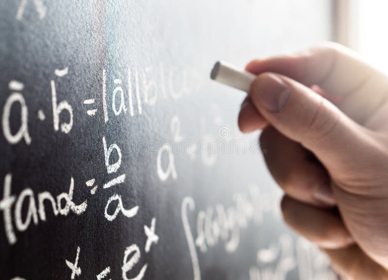 Nauczyciel pisze blackboard z kredą Uczeń i chalkboard zdjęcie stock Nauczyciel pisze blackboard z kredą Uczeń i chalkboard zdjęcie stock