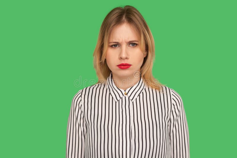 Naughty woman in bad mood. Beautiful blond girl with bright red lips in striped blouse frowning face looking displeased