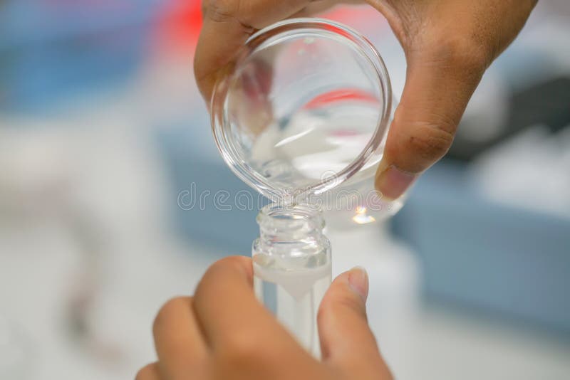 Naukowa dolewania ciecz od Erlenmeyer kolby pomiar t zdjęcia royalty free Naukowa dolewania ciecz od Erlenmeyer kolby pomiar t zdjęcia royalty free