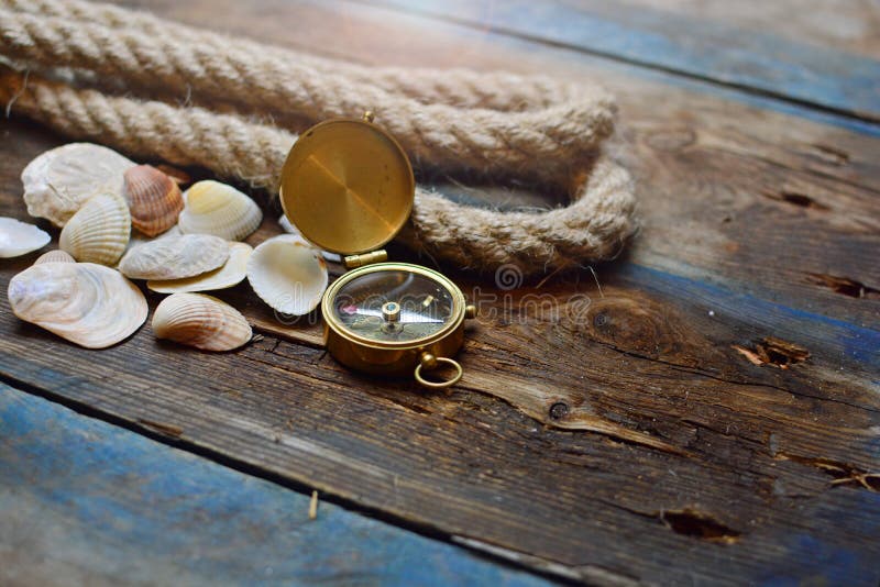 Nautical background. Old deck with rope, compass and shells