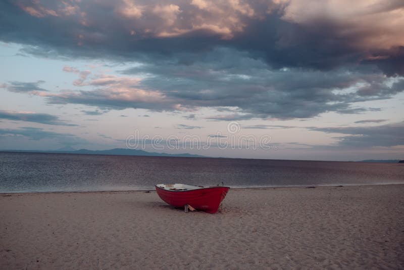 Nave da pesca in mare, sabbia al tramonto con fondo marino di orbitante. Il mare con onde e cielo nuvoloso immagini stock Nave da pesca in mare, sabbia al tramonto con fondo marino di orbitante. Il mare con onde e cielo nuvoloso immagini stock