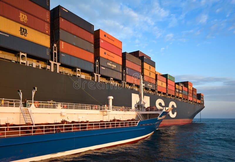 Nave porta-container di Zaliv America dell'autocisterna di Bunkering MSC Bruxelles Baia del Nakhodka Mare orientale (del Giappone immagine stock libera da diritti Nave porta-container di Zaliv America dell'autocisterna di Bunkering MSC Bruxelles Baia del Nakhodka Mare orientale (del Giappone immagine stock libera da diritti
