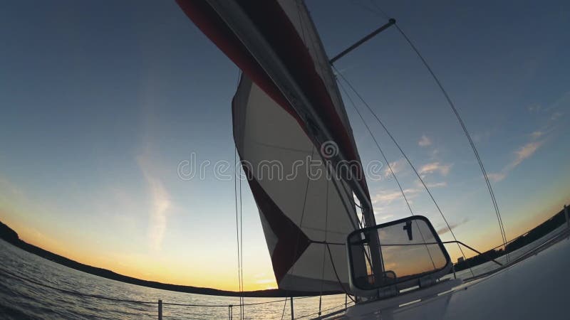 Navegación del yate en agua abierta La vela agita en el viento, barco pasa a través del agua Paisaje hermoso del agua en puesta d