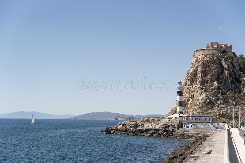 Navigazione della barca a vela accanto al faro di Aguilas in Spagna fotografie stock Navigazione della barca a vela accanto al faro di Aguilas in Spagna fotografie stock