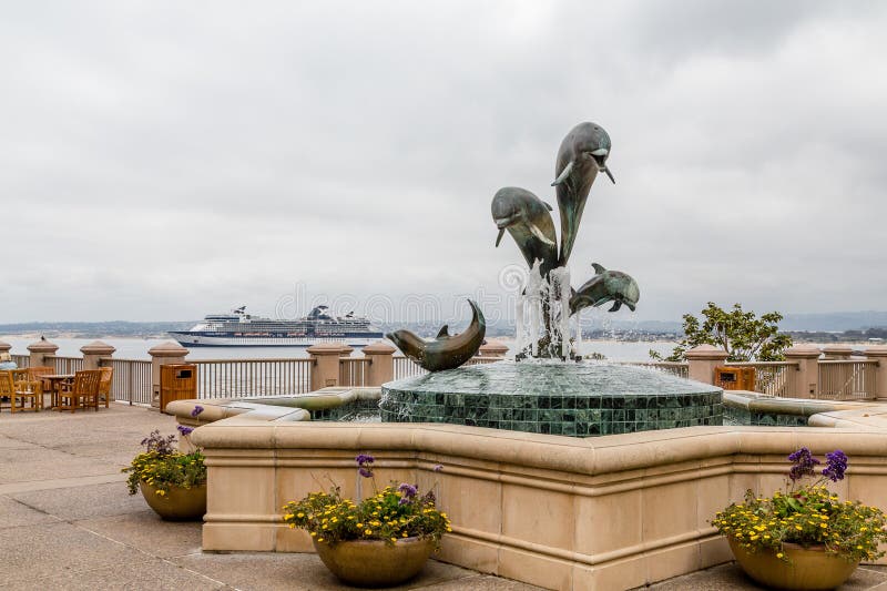 Dolphin fountain in Cannery Row near Monterey with Cruise Ship in Background. Dolphin fountain in Cannery Row near Monterey with Cruise Ship in Background