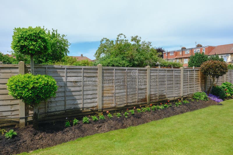 Neat flower bed with garden fence and lawn.