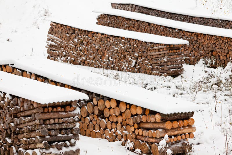 Neatly stacked fire wood as sustainable renewable heat source covered in snow. Neatly stacked fire wood as sustainable renewable heat source covered in snow