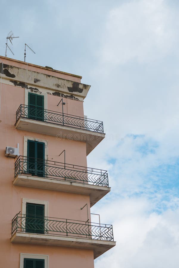 nedersta sikt av balkonger av gammal byggnad framme av molnig himmel, royaltyfri fotografi nedersta sikt av balkonger av gammal byggnad framme av molnig himmel, royaltyfri fotografi
