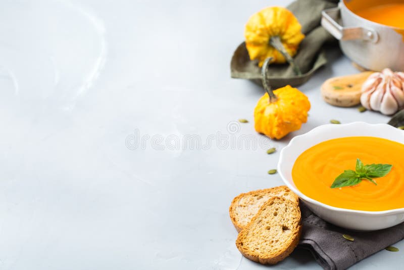 Nedgånghösten grillade orange pumpamorotsoppa med vitlök arkivbild Nedgånghösten grillade orange pumpamorotsoppa med vitlök arkivbild