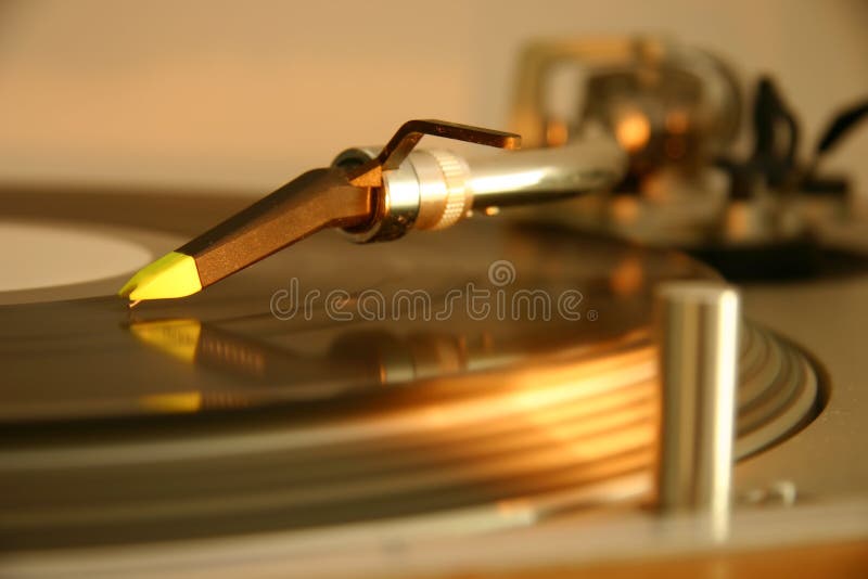 Needle and cartridge on a silver DJ turntable