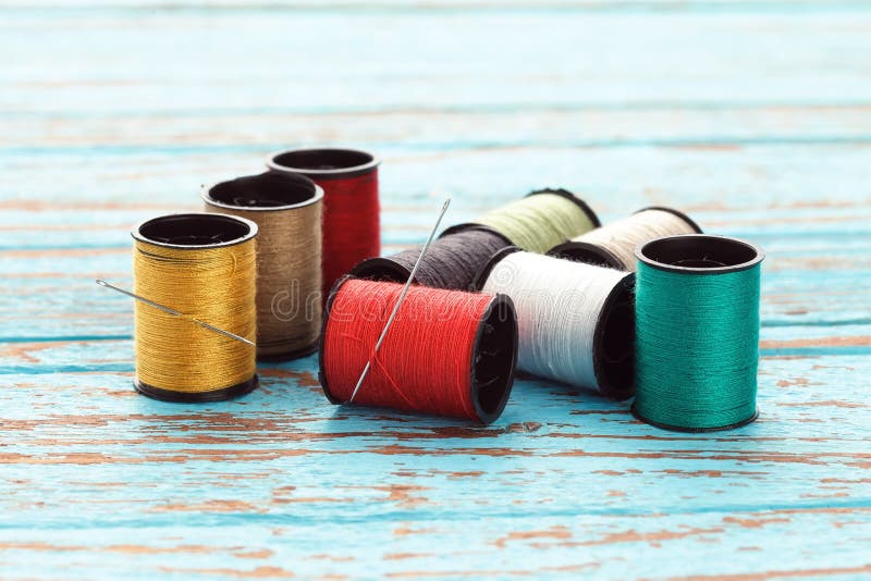 Needle colorful thread needlework embroidery tailor craft repair background blue wood teak still life vintage