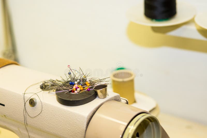 Needlework, выстегивающ, шьющ и портняжничающ концепцию - красочные штыри на магните на швейной машине, инструменты крупный план, стоковое фото Needlework, выстегивающ, шьющ и портняжничающ концепцию - красочные штыри на магните на швейной машине, инструменты крупный план, стоковое фото