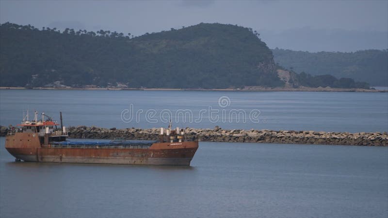 Neglected ocean carrier near stones jetty, Conakry