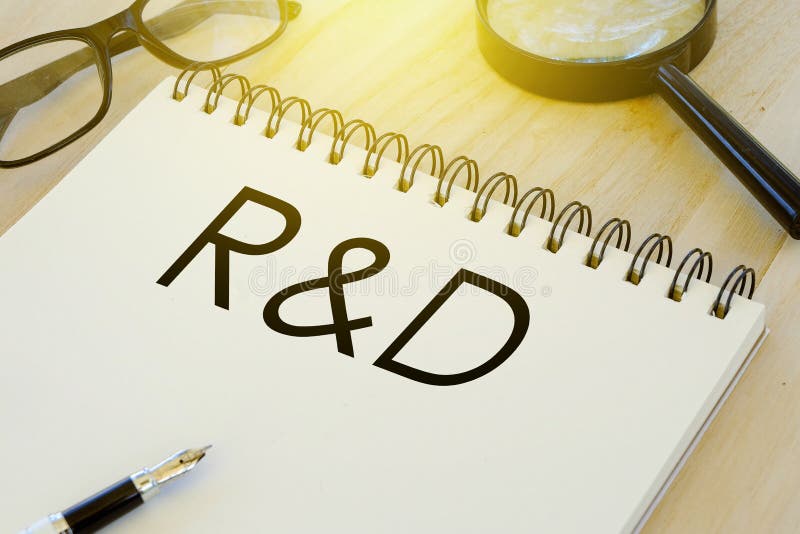 Negocio y finanzas conceptuales Gafas de sol, pluma, lupa y cuaderno escritos con la investigación y desarrollo del R&D en la mad foto de archivo libre de regalías Negocio y finanzas conceptuales Gafas de sol, pluma, lupa y cuaderno escritos con la investigación y desarrollo del R&D en la mad foto de archivo libre de regalías