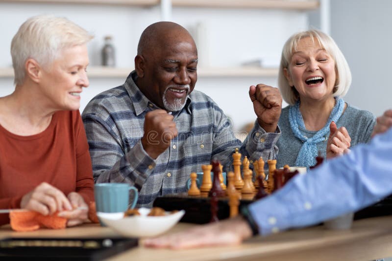 Amigos de xadrez e jogos de tabuleiro na mesa de madeira pensando em  movimento estratégico ou tático em casa grupo sênior de homens jogando e  segurando ou movendo a peça branca para