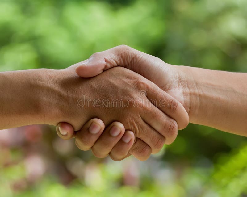 Hands shake over nature background. Hands shake over nature background