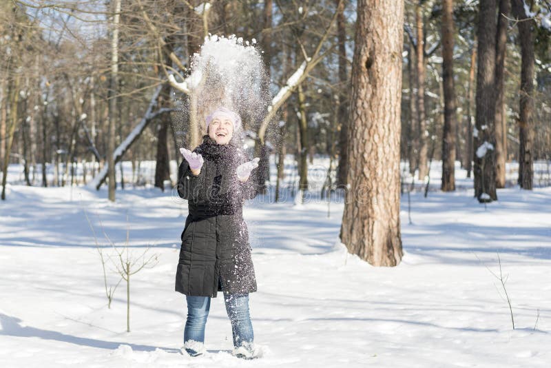 Neige de lancement de fille heureuse de combat de neige d'hiver jouant dehors Jeune femme joyeuse ayant l'amusement en nature For photographie stock Neige de lancement de fille heureuse de combat de neige d'hiver jouant dehors Jeune femme joyeuse ayant l'amusement en nature For photographie stock