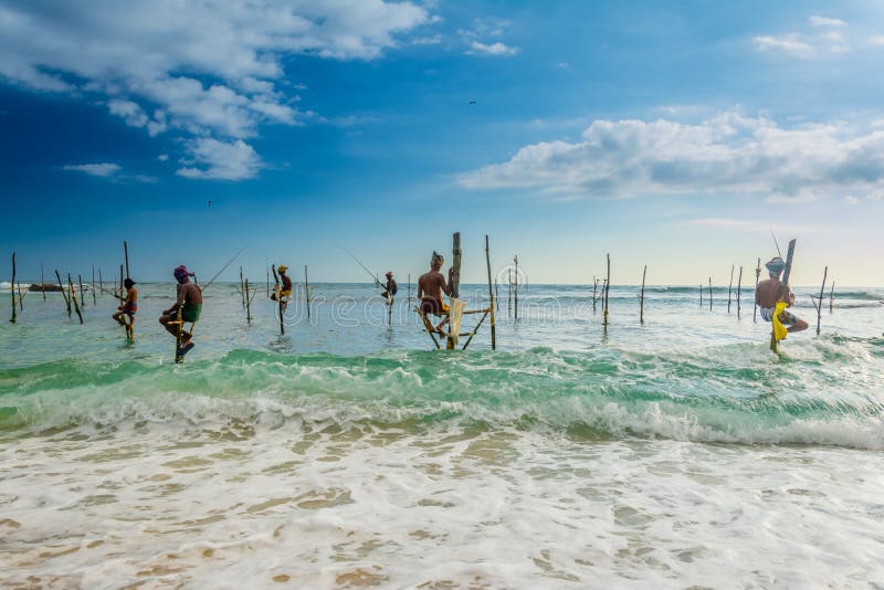 Nello Sri Lanka, un pescatore locale sta pescando nello stile unico nella sera fotografia stock Nello Sri Lanka, un pescatore locale sta pescando nello stile unico nella sera fotografia stock