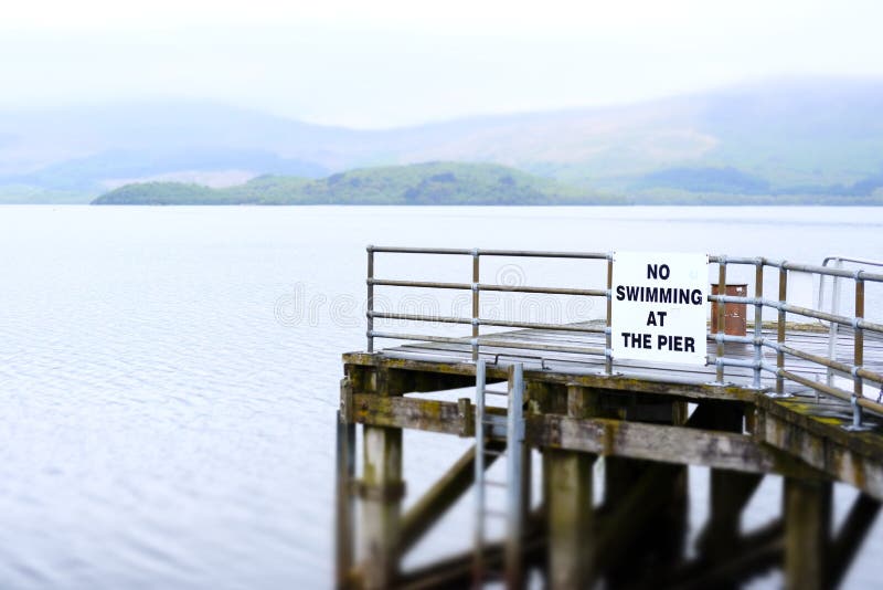 Nenhuma natação no perigo do sinal de aviso de Loch Lomond Luss das águas profundas do molhe do cais da morte fotografia de stock Nenhuma natação no perigo do sinal de aviso de Loch Lomond Luss das águas profundas do molhe do cais da morte fotografia de stock