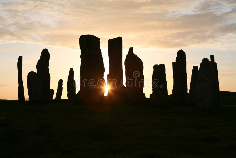 Sun setting behind the neolithic stone circle at Callanish, Isle of Lewis, Outer Hebrides. Sun setting behind the neolithic stone circle at Callanish, Isle of Lewis, Outer Hebrides