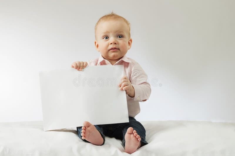 Neonato che tiene spazio in bianco bianco Bambino infantile che si siede con il manifesto in sue mani Derisione su Copi lo spazio immagine stock libera da diritti Neonato che tiene spazio in bianco bianco Bambino infantile che si siede con il manifesto in sue mani Derisione su Copi lo spazio immagine stock libera da diritti