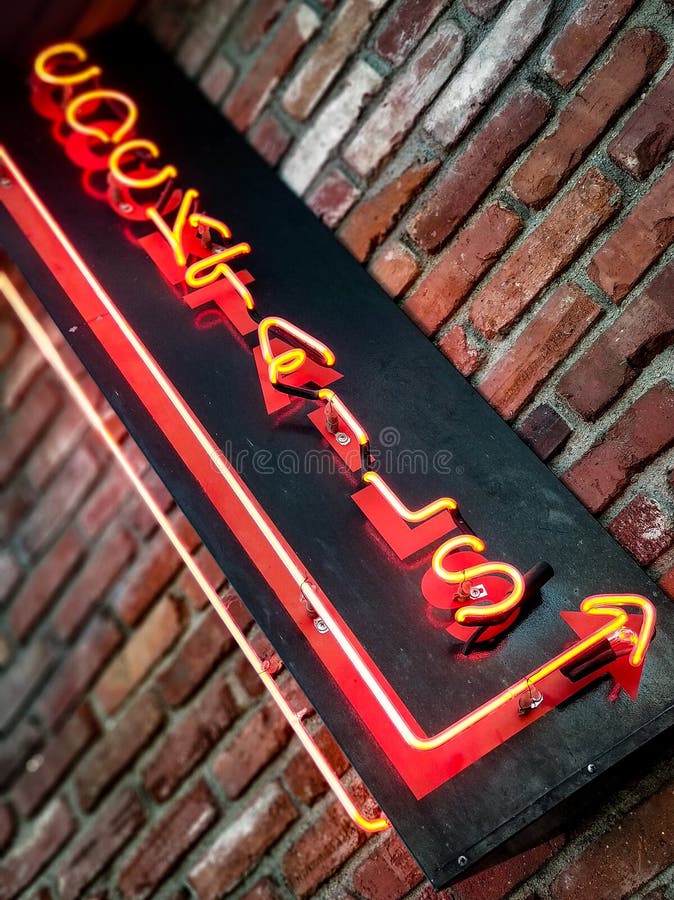 Neoncocktailzeichen auf verwittertem Ziegelstein lizenzfreie stockfotos