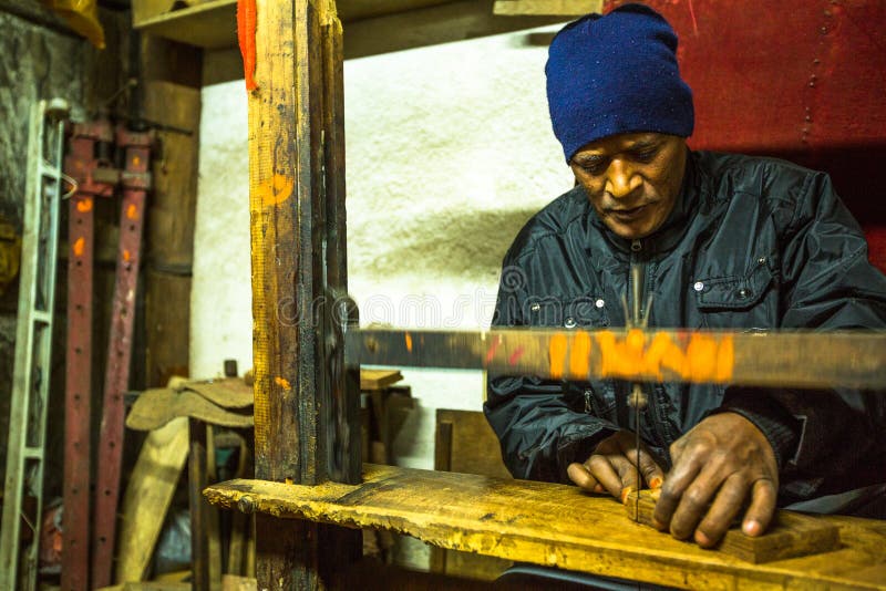 Nepalese man working in his wooden workshop. stock image