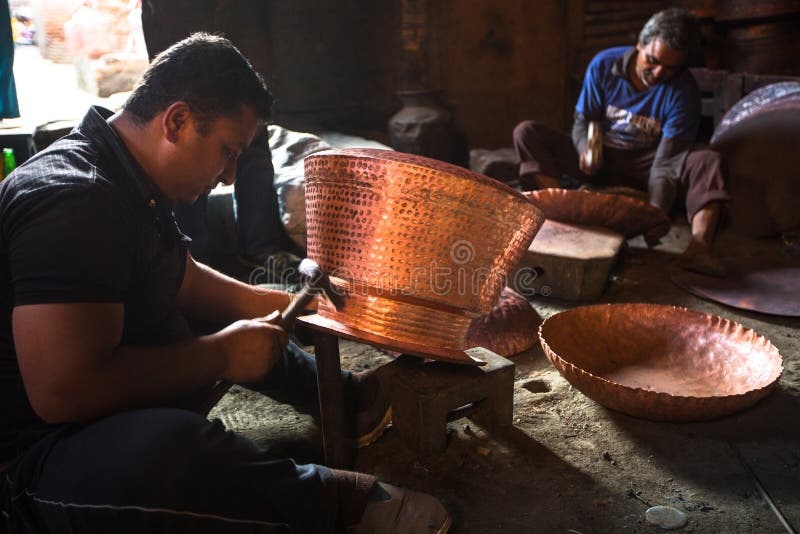 Nepalese tinmans working in the his workshop. royalty free stock image