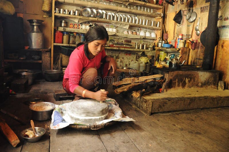 Nepalese woman mills rice, Nepal