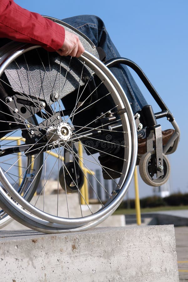 Closeup of wheelchair woman going down the concrete kerb. Closeup of wheelchair woman going down the concrete kerb