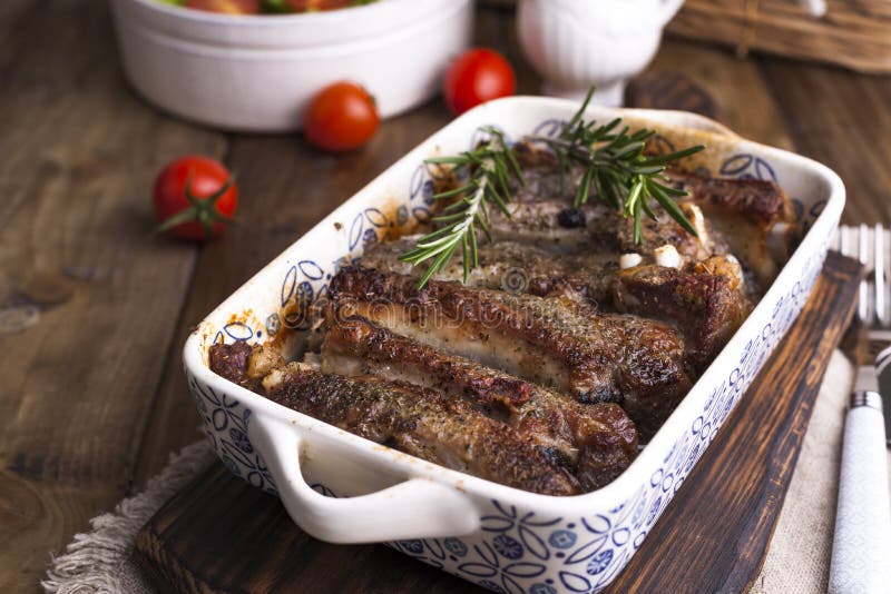 Nervature di porco cotte Carne con le spezie e le erbe in piatti su fondo di legno Pranzo per un barbecue Spazio libero per il te immagini stock Nervature di porco cotte Carne con le spezie e le erbe in piatti su fondo di legno Pranzo per un barbecue Spazio libero per il te immagini stock