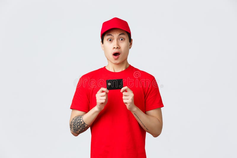 Nervous Asian Delivery Guy In Red T Shirt And Cap Uniform Holding