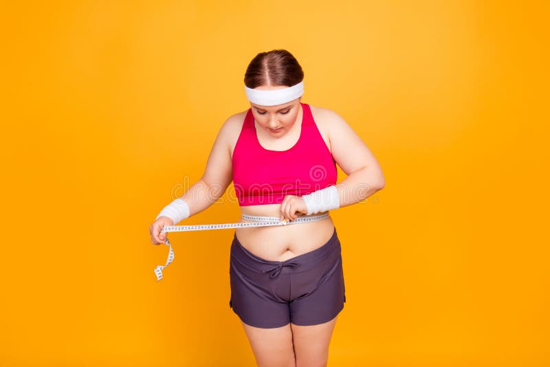 Nervous sportive fat woman wearing pink top and dark shorts is m royalty free stock images Nervous sportive fat woman wearing pink top and dark shorts is m royalty free stock images