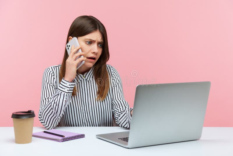 Nervous unhappy woman office worker talking phone with client sitting at workplace, manager making order on laptop, booking