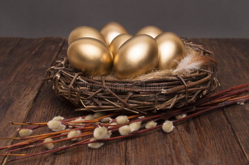 Nest met gouden eieren met wilg op een houten achtergrond Pasen royalty-vrije stock fotografie Nest met gouden eieren met wilg op een houten achtergrond Pasen royalty-vrije stock fotografie