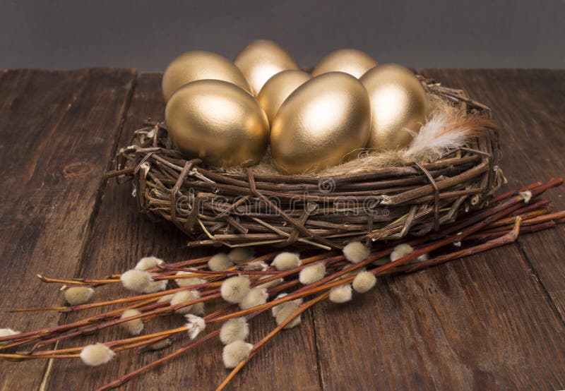Nest met gouden eieren met wilg op een houten achtergrond Pasen royalty-vrije stock afbeelding Nest met gouden eieren met wilg op een houten achtergrond Pasen royalty-vrije stock afbeelding