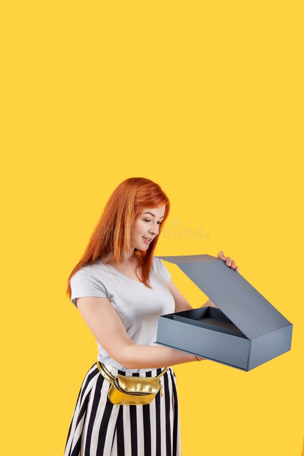 Eine nette, angenehme Frau öffnet die Schachtel lizenzfreie stockfotos