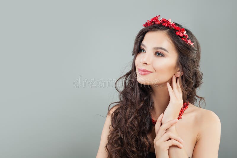 Nette brunette vorbildliche Frau, die oben auf grauem Fahnenhintergrund lächelt und schaut lizenzfreies stockfoto