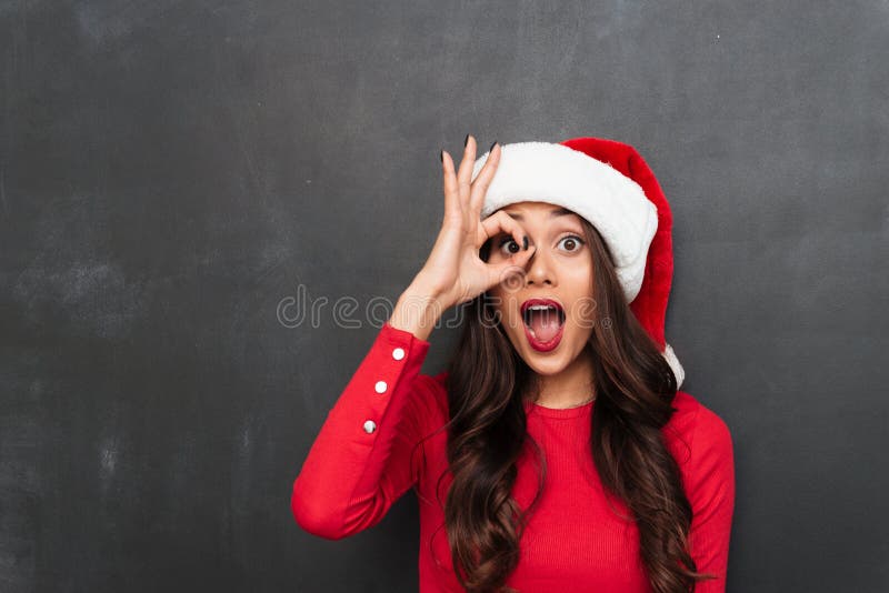 Nette Brunettefrau im roten Blusen- und Weihnachtshut stockbilder