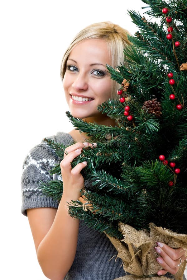 Nette Frau, die ein christmastree lächelt und anhält stockbild Nette Frau, die ein christmastree lächelt und anhält stockbild