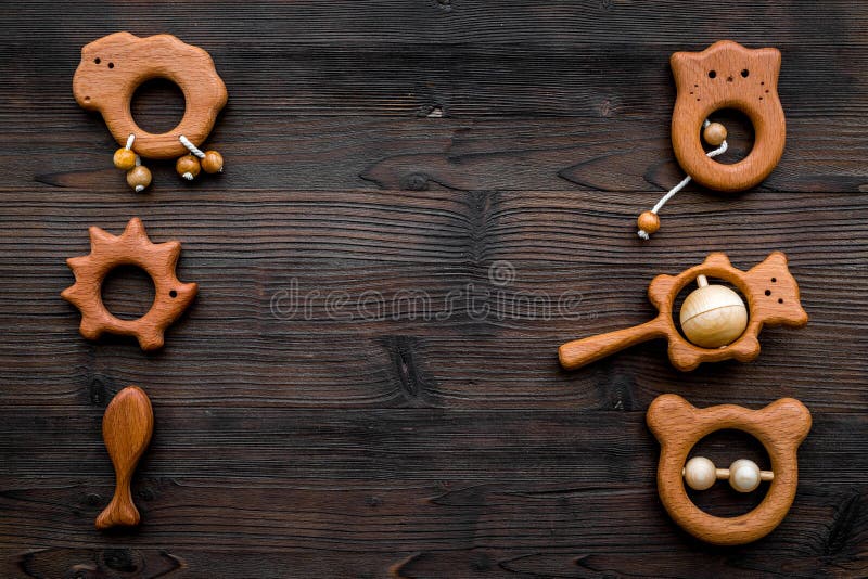 Nette hölzerne handgemachte Spielwaren für neugeborenes auf dunklem hölzernem copyspace Draufsicht des Hintergrundes. Nette hölzerne handgemachte Spielwaren für neugeborenes auf Draufsicht des dunklen hölzernen Hintergrundes