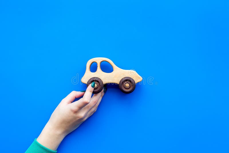 Nette hölzerne handgemachte Spielwaren für neugeborenes Übergeben Sie Griffautospielzeug auf blauem copyspace Draufsicht des Hint stockbilder