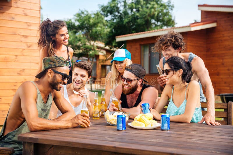 Nette junge Freunde, die Sommerfest des Bieres im Freien trinken lizenzfreies stockfoto Nette junge Freunde, die Sommerfest des Bieres im Freien trinken lizenzfreies stockfoto