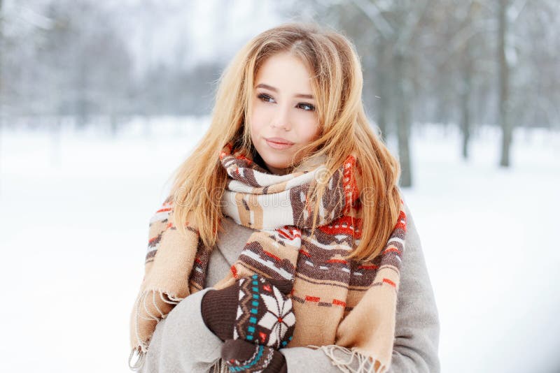 Nette junge reizend zarte Frau mit stilvollem Schal der Weinlese im modischen warmen grauen Mantel mit der gestrickten Handschuha lizenzfreie stockfotografie Nette junge reizend zarte Frau mit stilvollem Schal der Weinlese im modischen warmen grauen Mantel mit der gestrickten Handschuha lizenzfreie stockfotografie