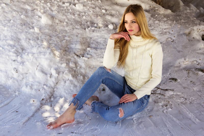 Nette schöne Jugendliche, die im Schnee sitzt stockfoto Nette schöne Jugendliche, die im Schnee sitzt stockfoto