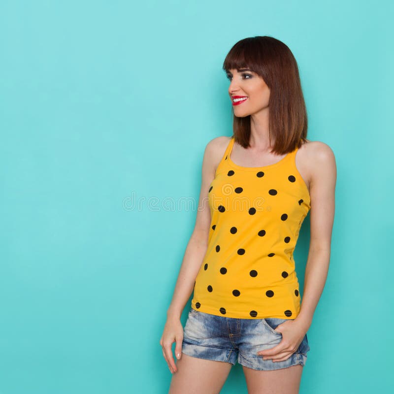 Nette schöne junge Frau im gelben Trägershirt-Aufpassen stockfotografie Nette schöne junge Frau im gelben Trägershirt-Aufpassen stockfotografie