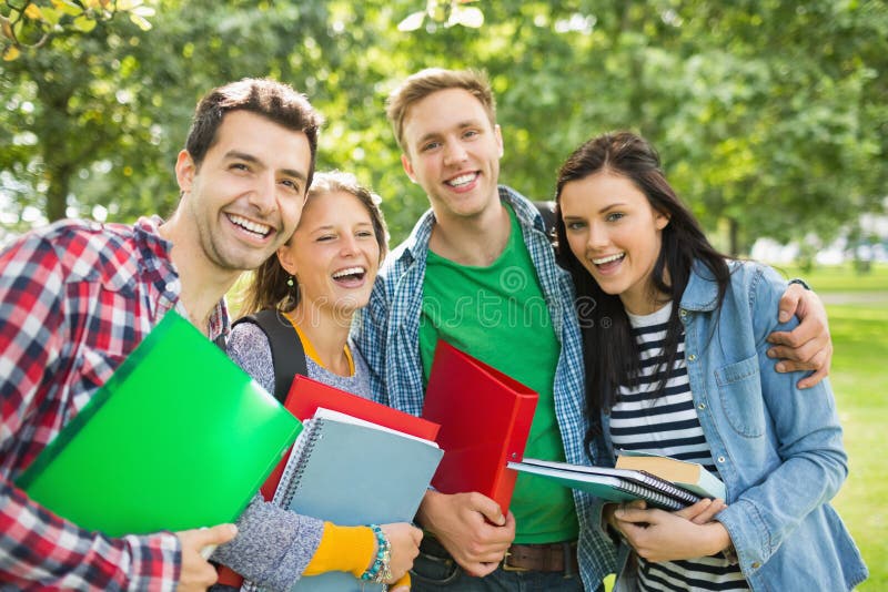 Nette Studenten mit Taschen und Bücher im Park lizenzfreie stockfotos Nette Studenten mit Taschen und Bücher im Park lizenzfreie stockfotos