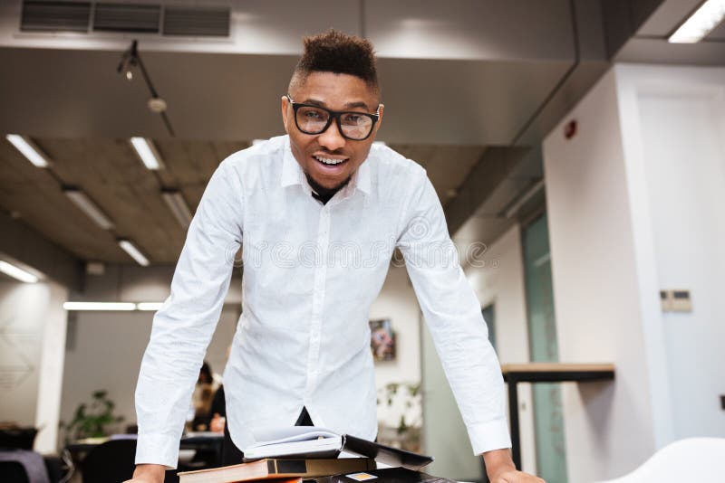 Netter afrikanischer Student in der Bibliothek Bildungsmaterial lernend lizenzfreie stockfotografie Netter afrikanischer Student in der Bibliothek Bildungsmaterial lernend lizenzfreie stockfotografie