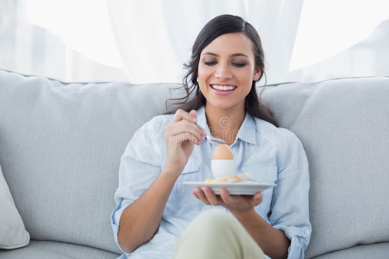 Netter Brunette, der Ei isst lizenzfreies stockfoto