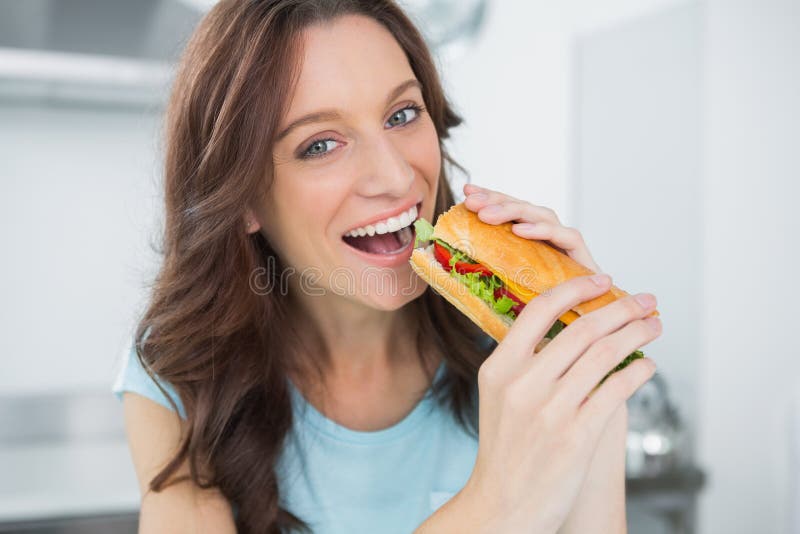 Netter Brunette, der Sandwich isst lizenzfreies stockfoto